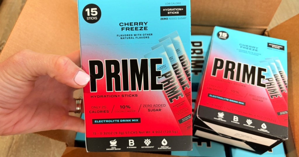 Hand holding boxes of cherry freeze prime hydration sticks