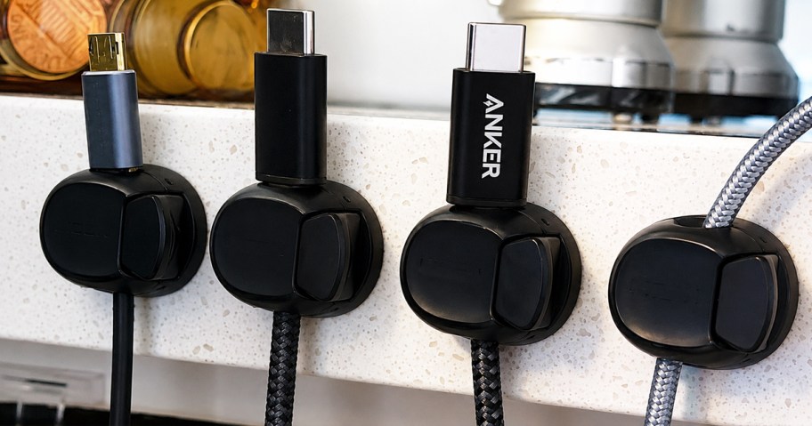 charing cords held by black clips on edge of counter