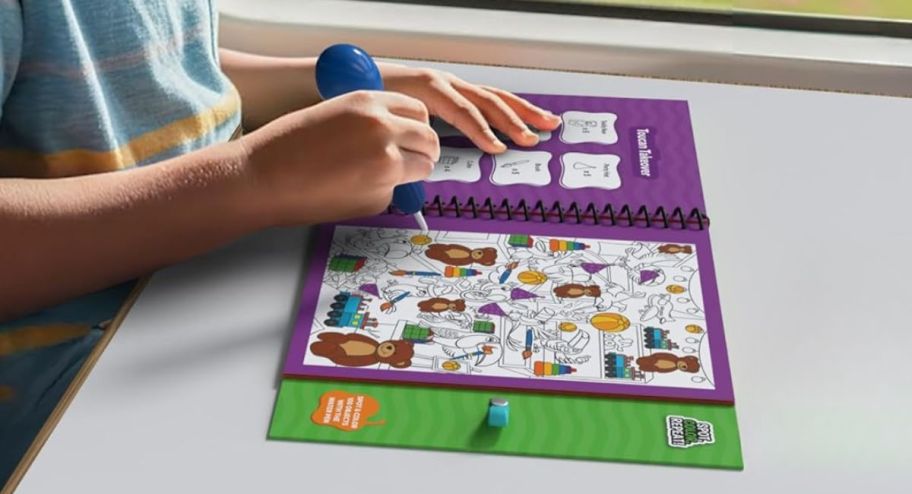 child playing with a child coloring water book displayed on the table