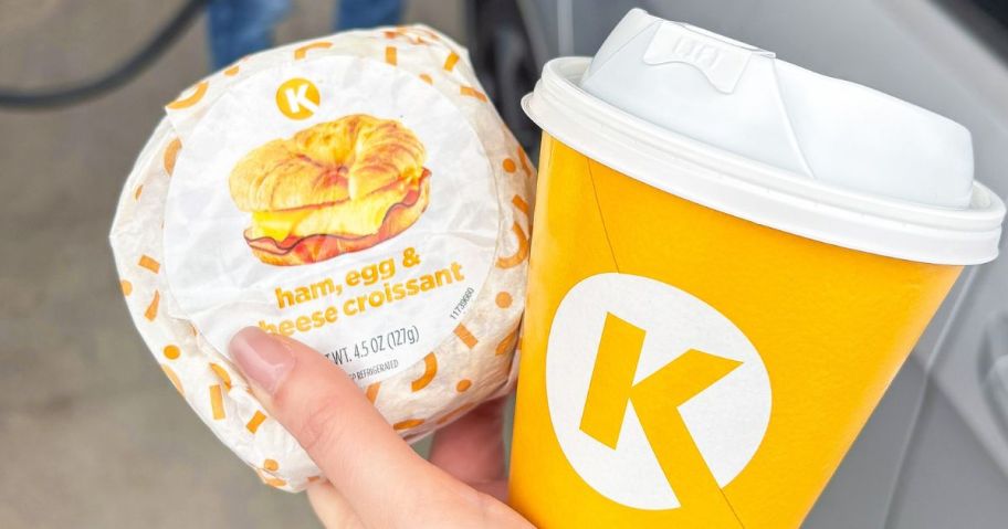 hand holding a Circle K Breakfast Sandwich and Hot beverage in a Circle K Cup