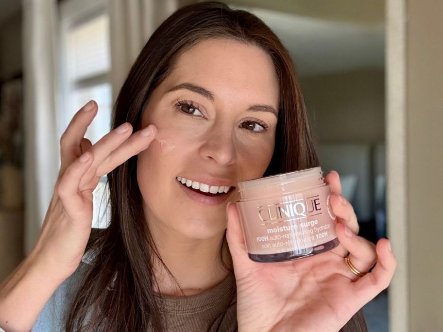Woman applying Clinique Moisture Surge to her face