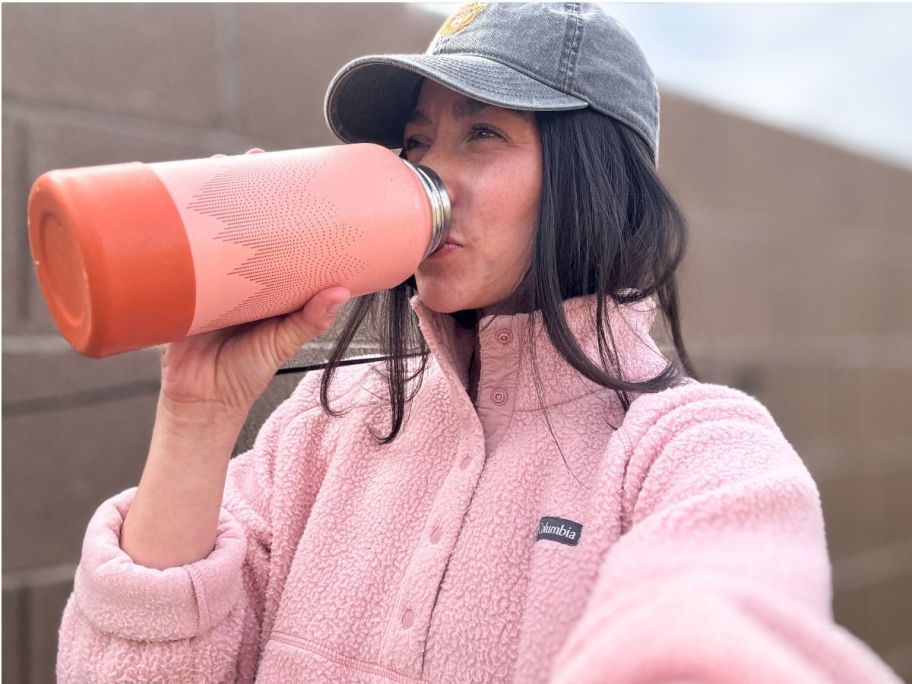 Woman wearing a Columbia fleece while drinking from a water bottle