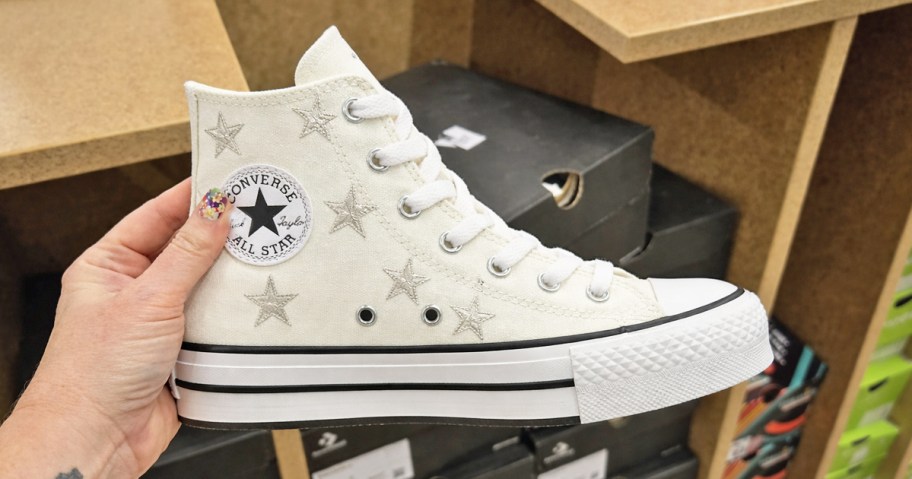 hand holding a star print converse high top sneaker