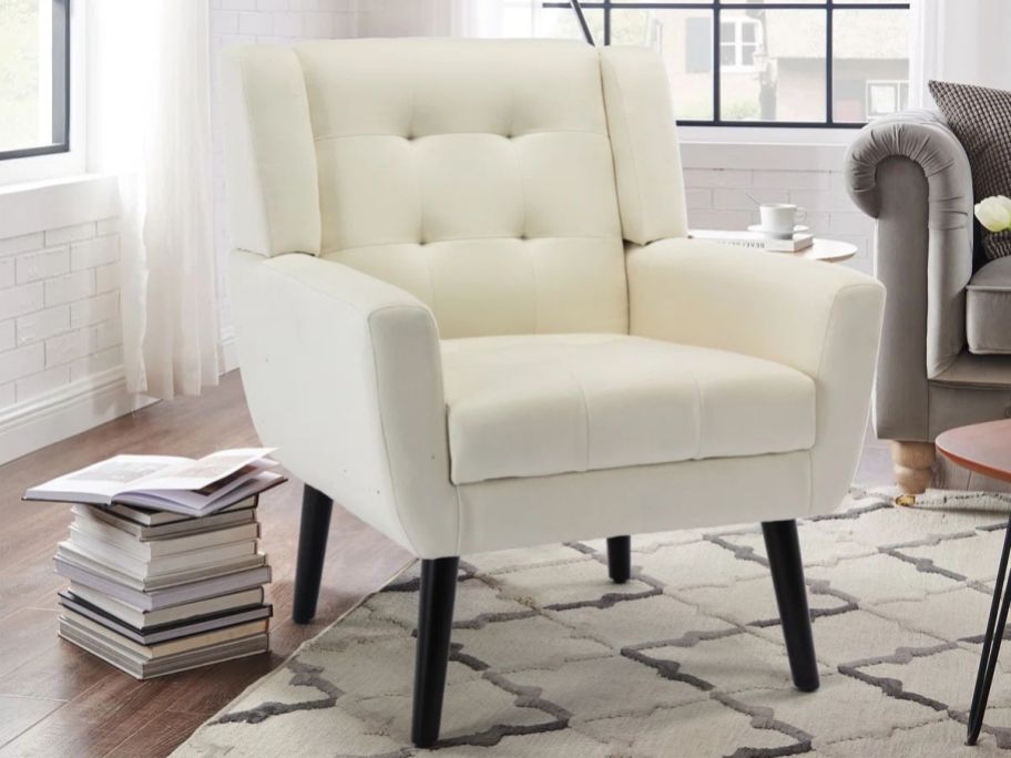 Corrigan Studio Tufted Upholstered Wide Back Armchair in living room