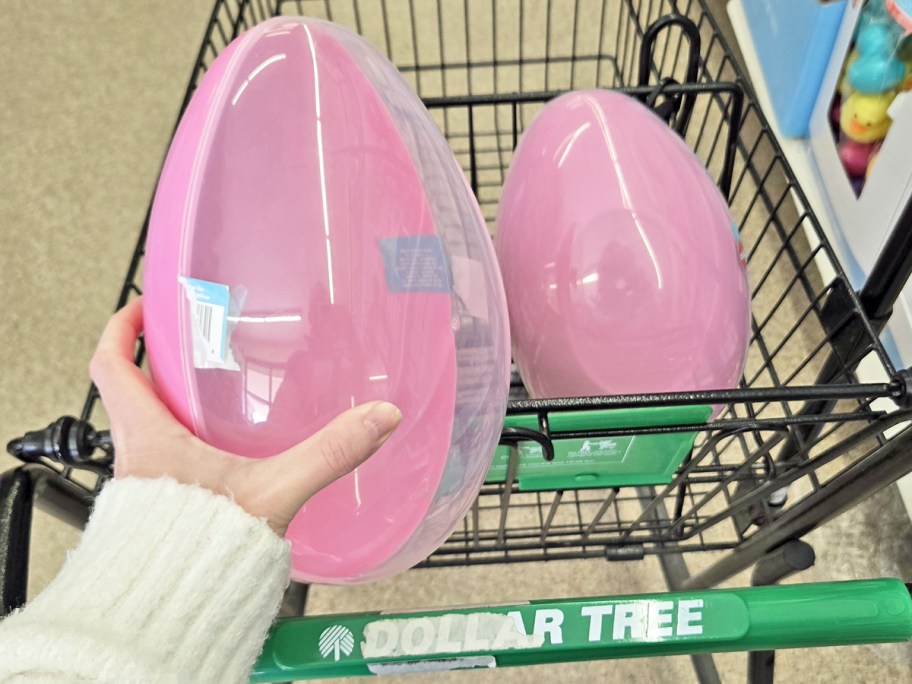 hand holding up a large pink plastic easter egg