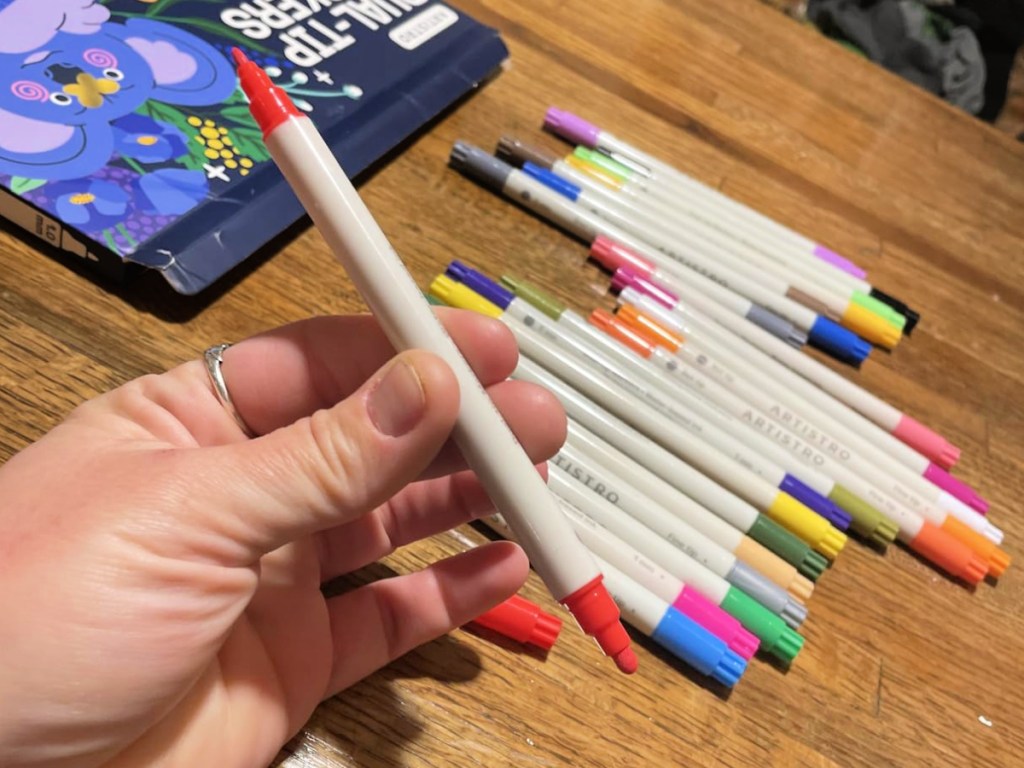 Hand holding up dual sided paint marker