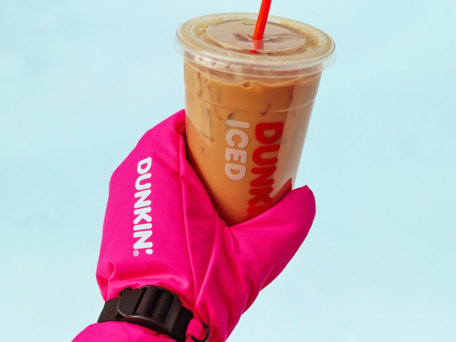 hand in a pink glove holding a dunkin' iced coffee