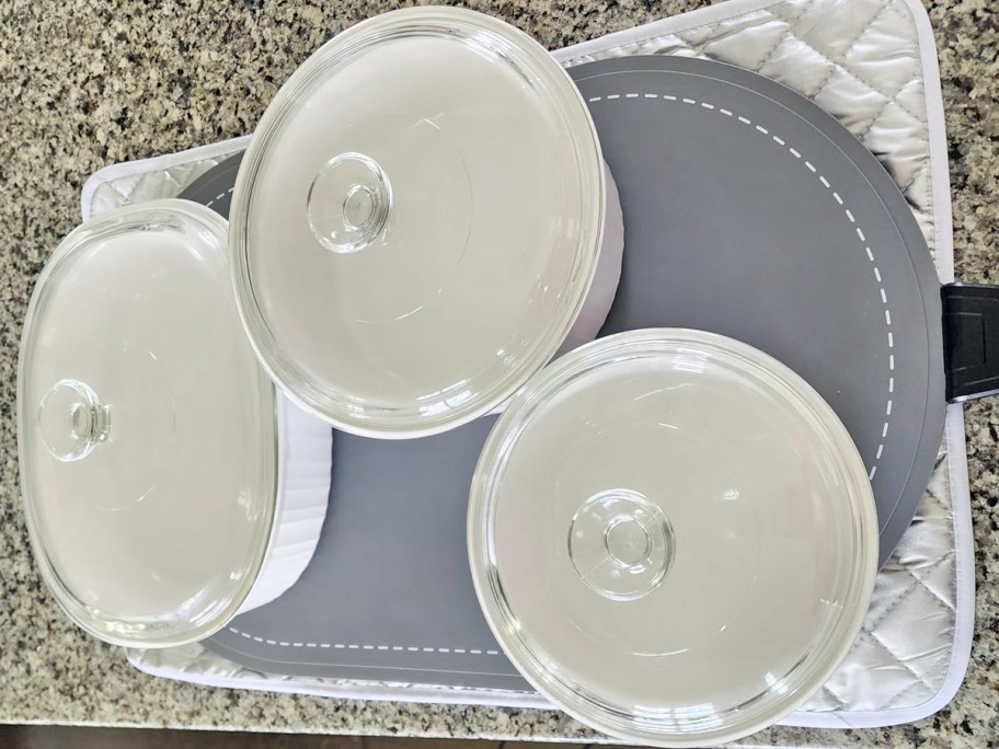 3 casserole dishes on a grey food warming mat