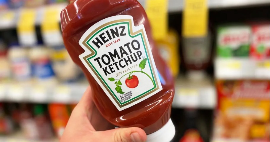 hand holding up a bottle of Heinz Tomato Ketchup in store