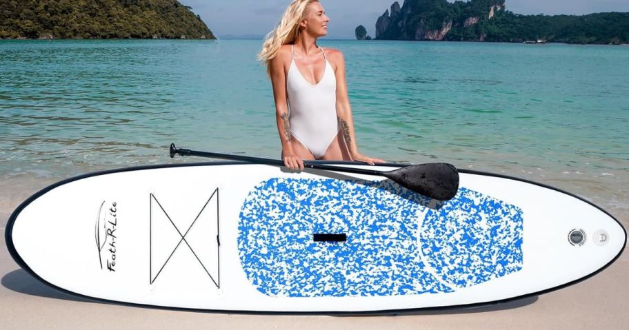 Woman on a beach with an inflatable paddle board