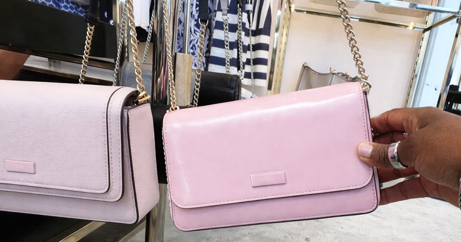hand holding a light pink kate spade crossbody bag