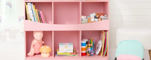 Pink kids bookshelf, filled with toys and books