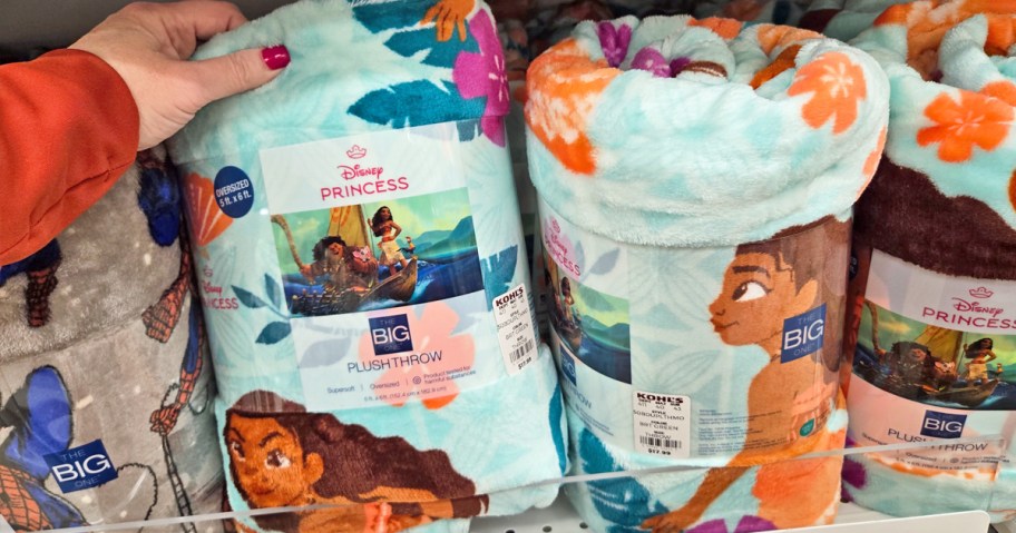 hand grabbing a moana print throw blanket from store shelf