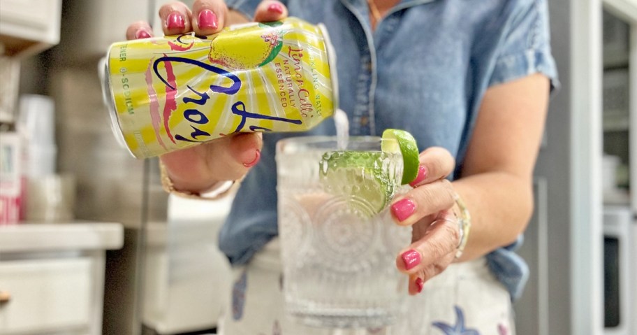 woman pouring a can of LaCroix into a glass with ice