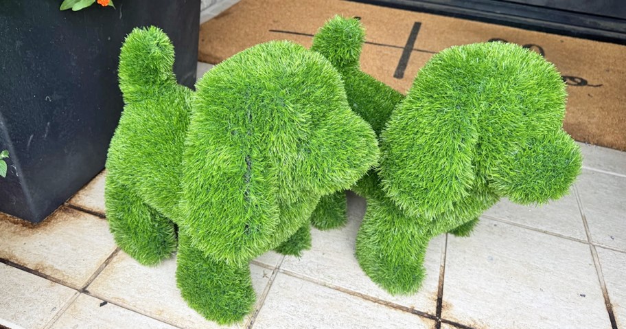 green dog-shaped topiaries on front porch