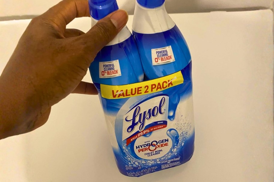 person holding two bottles of lysol hydrogen peroxide toilet bowl cleaners