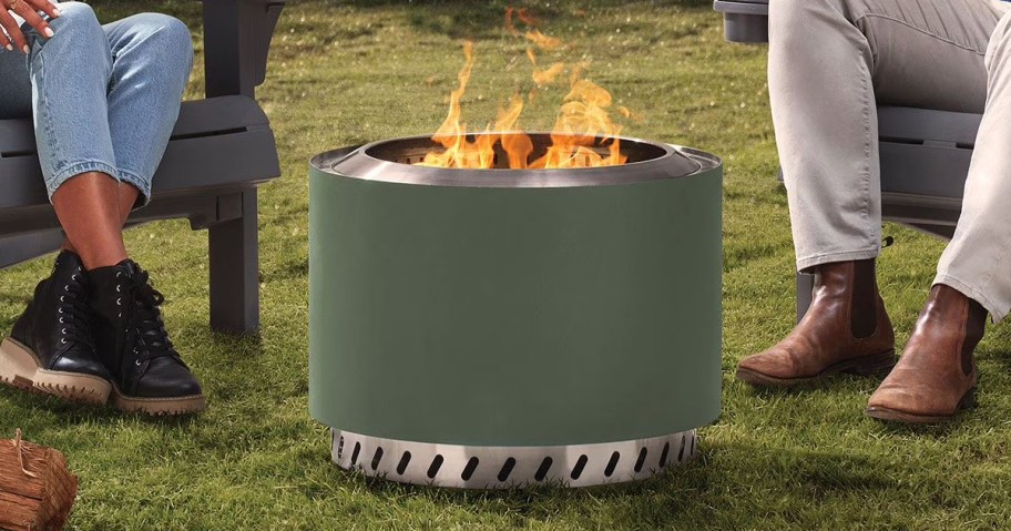 people sitting around a green fire pit