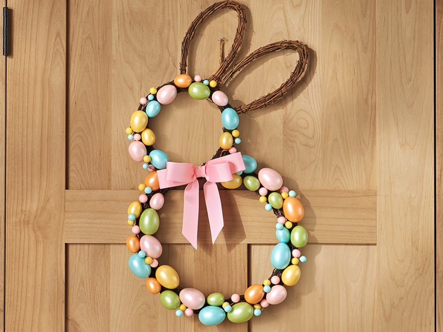 bunny shaped wreath with eggs on a wood door