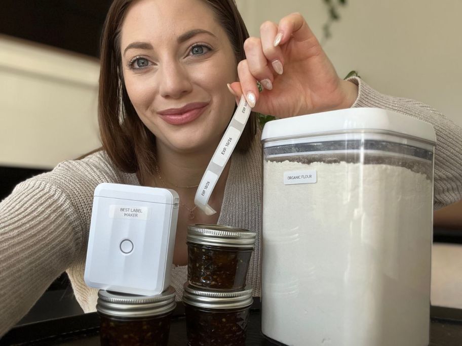 woman holding label strip next to containers