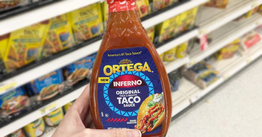 hand holding a bottle of Ortega Inferno Hot Taco Sauce in store