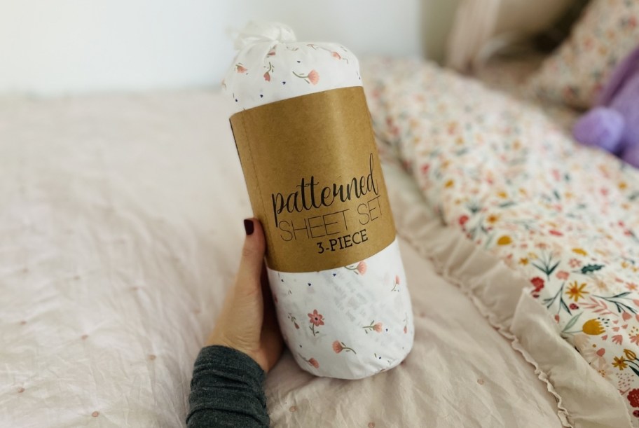 hand holding a rolled set of printed sheets 