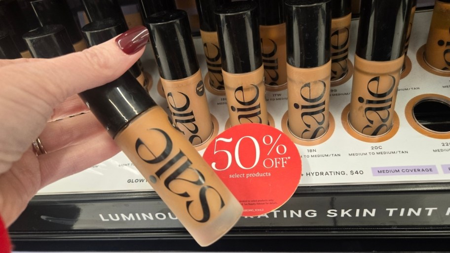 a hand holding a bottle of saie skin tint