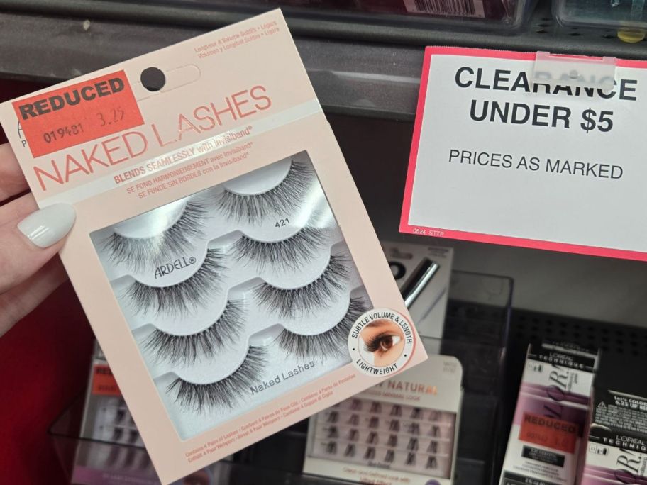 A hand holding a pack of fake eyelashes next to an Under $5 sign from Sally Beauty Supply.