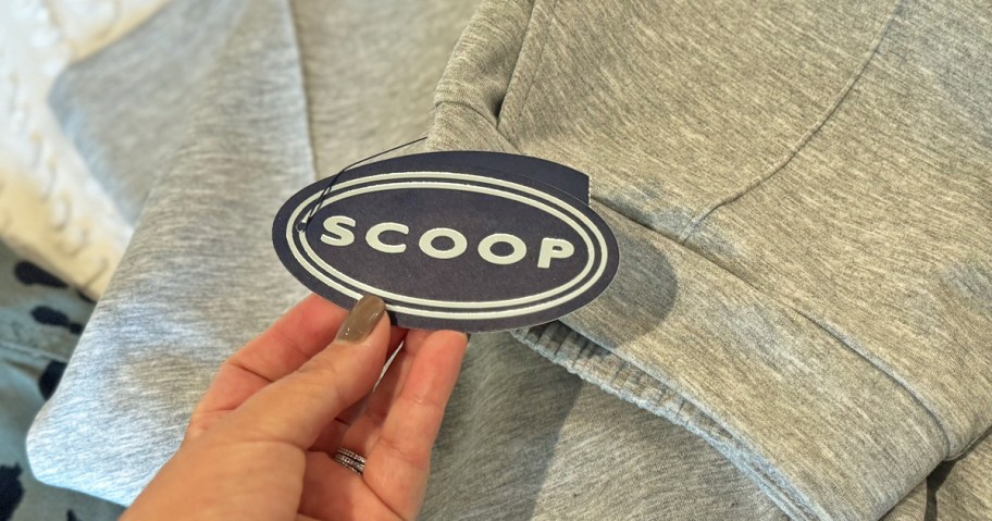 hand holding a scoop clothing tag