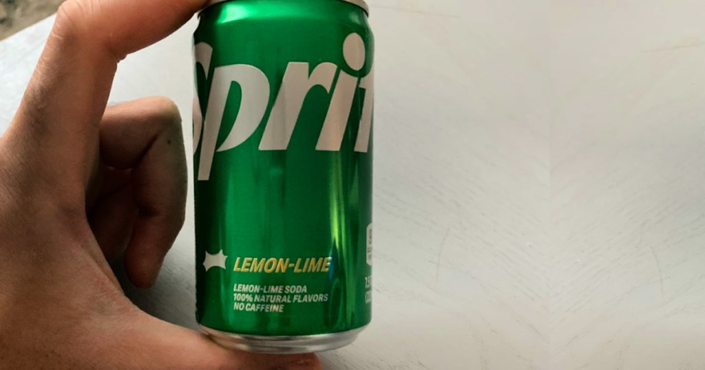 Hand holding sprite mini can