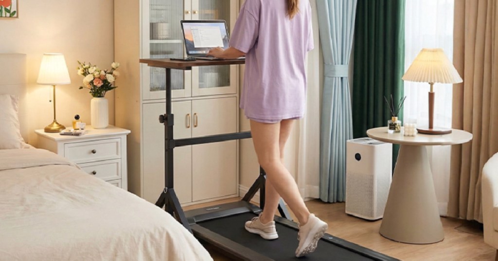 Woman using standing desk while walking on walking pad