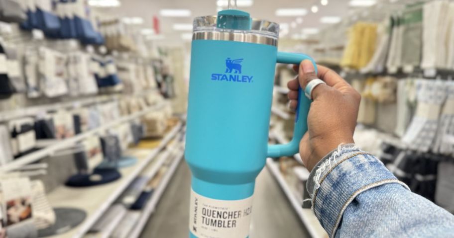 Hand holding a blkue Stanley Tumbler