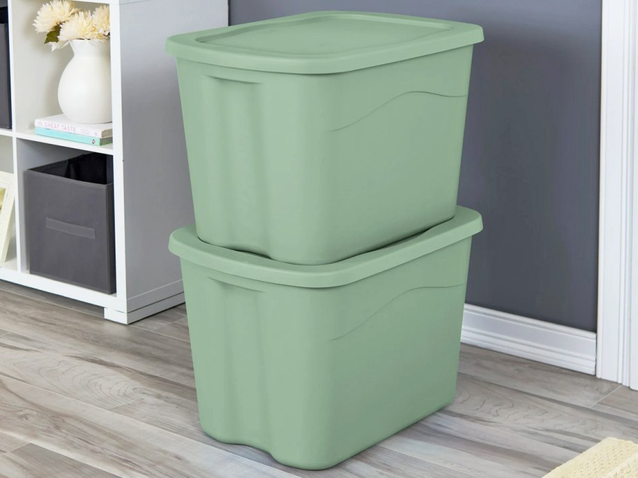 two stacked green storage totes