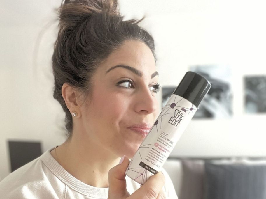 Woman holding a bottle of Style Edit Spray Root Concealer