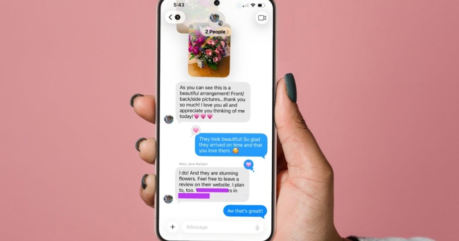 hand holding phone on pink background with flower delivery review