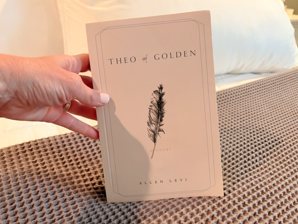 Hand holding Theo of golden book