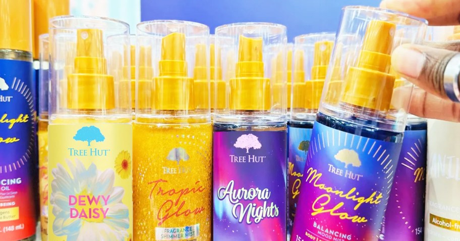 hand grabbing a bottle of Tree Hut Fragrance Mist from store shelf