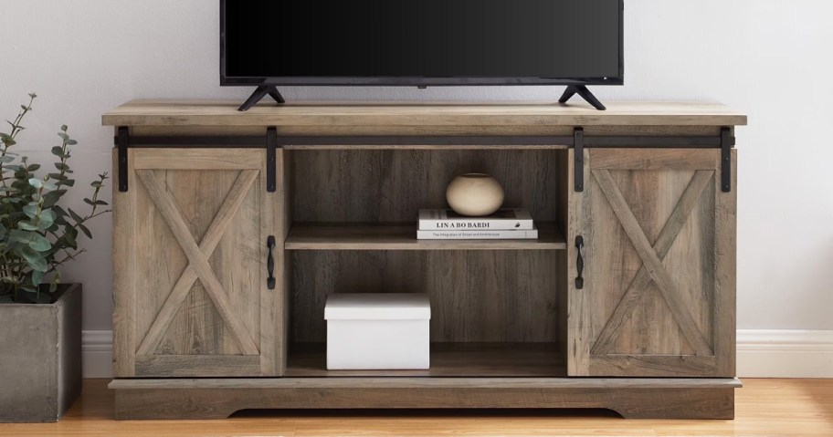 distressed wood tv stand with decor on the shelves