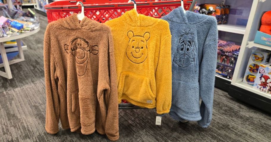 three winnie the pooh hoodies hung on a shopping cart