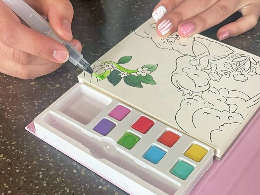 painting watercolor page in princess coloring book