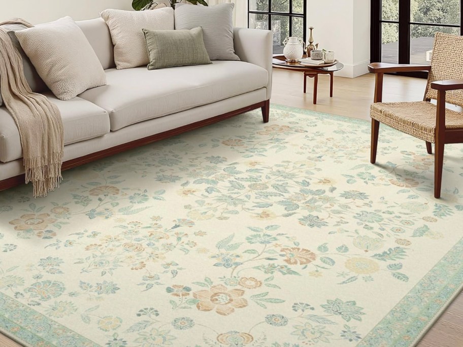 green floral rug in front of white couch