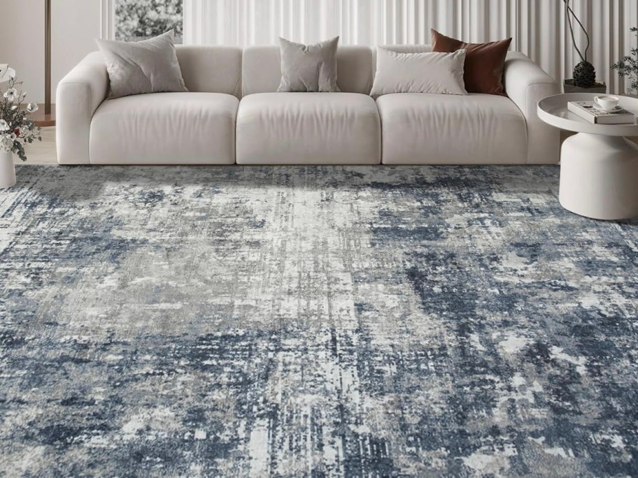 blue and white rug in front of white couch