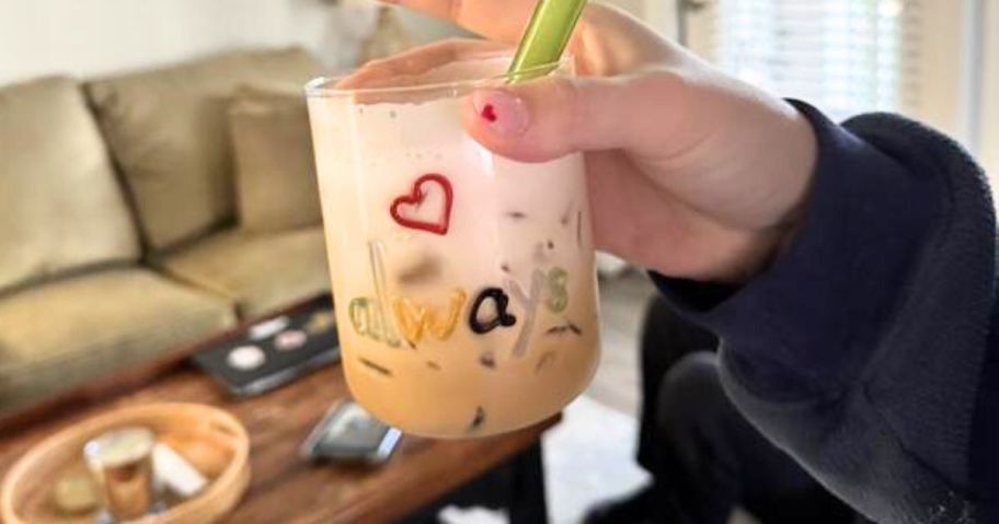 hand holding The Love Notes Icon Juice Glass with always written on it