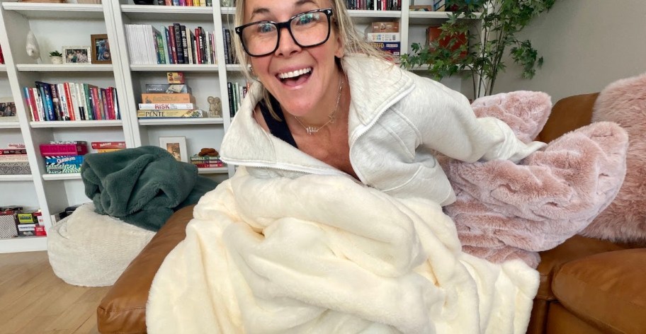 woman holding white faux fur blanket on couch