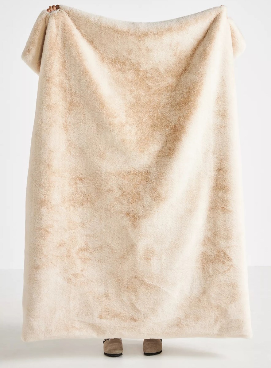 stock photo of person holding up large faux fur throw blanket