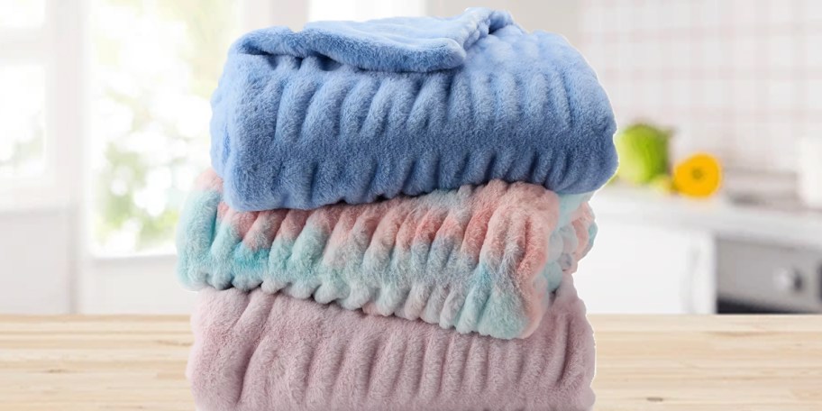 blue and pink throw blankets stacked 