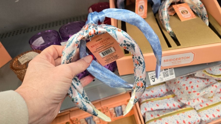 Woman's hands holding two Bridgerton headbands