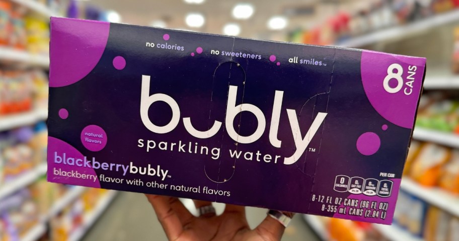 hand holding a pack of Bubly sparkling water canned drinks