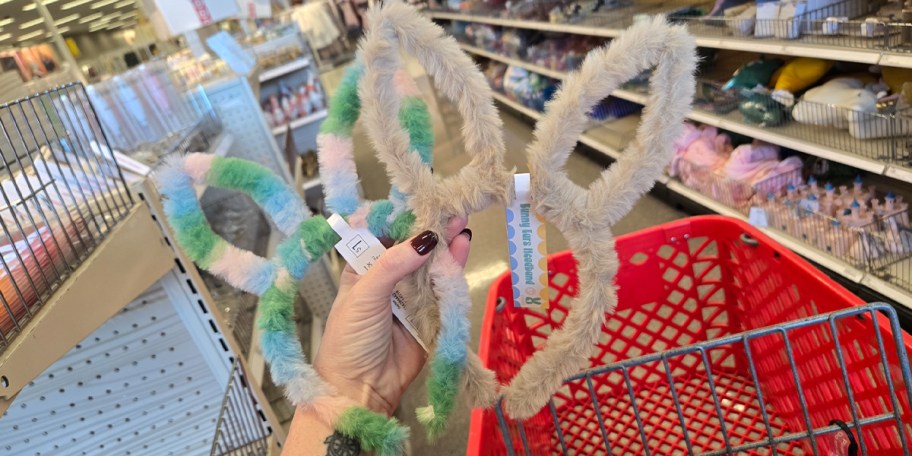 hand holding two pairs of bunny ear headbands 