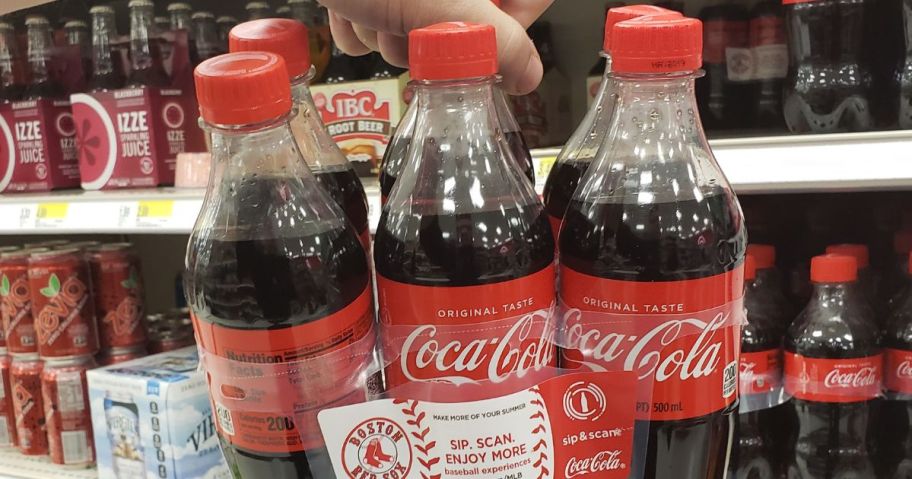 hand holding a 6-pack of Coca-Cola 16.9oz Bottles