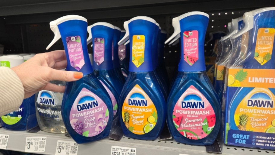 a womans hand grabbing a bottle dawn powerwash spray on a store shelf